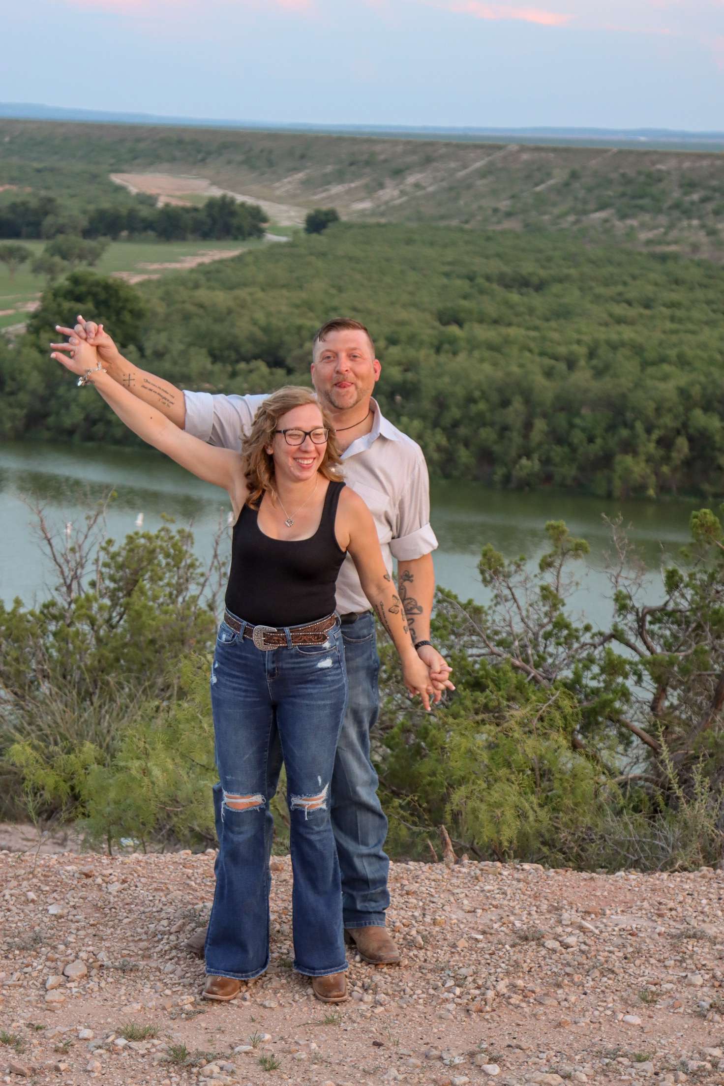 Devon and Lindy smiling together above a river overlook.